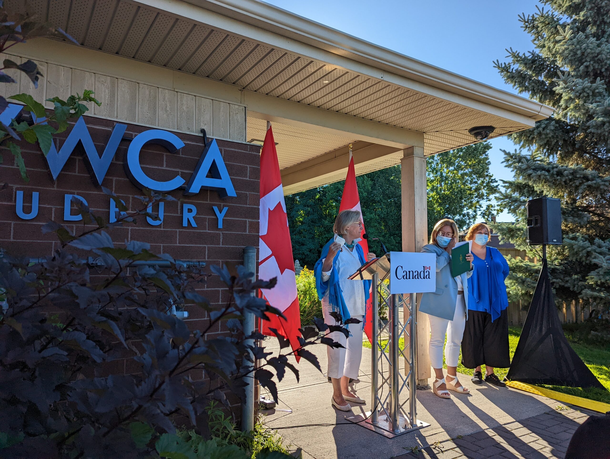 Hon. Minister Bennett, MP Lapointe, and YWCA Executive Director Marlene Gorman at the podium in front of the YWCA Sudbury building